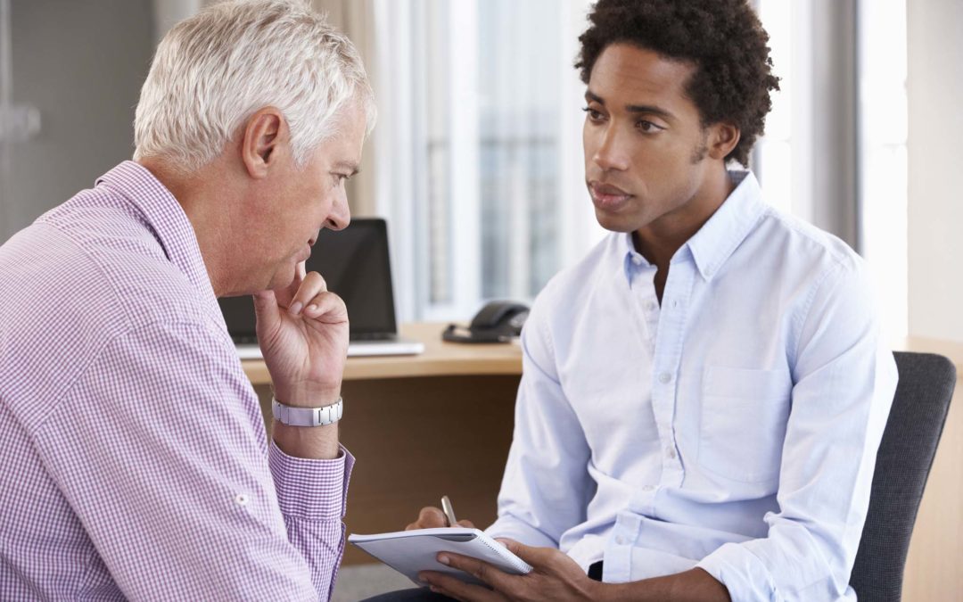 Middle Aged Man With Head In Hands Having Counselling Session