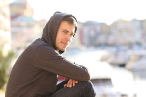 Teen in a hoodie looks at camera