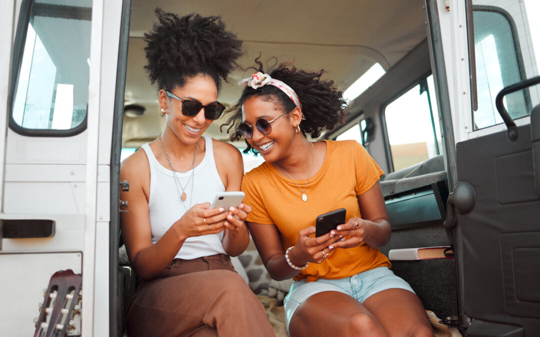 Women, road trip or phone for social media, gps location or map app for safari game drive or summer travel. Smile, happy or bonding friends with 5g mobile technology in camper van in nature landscape