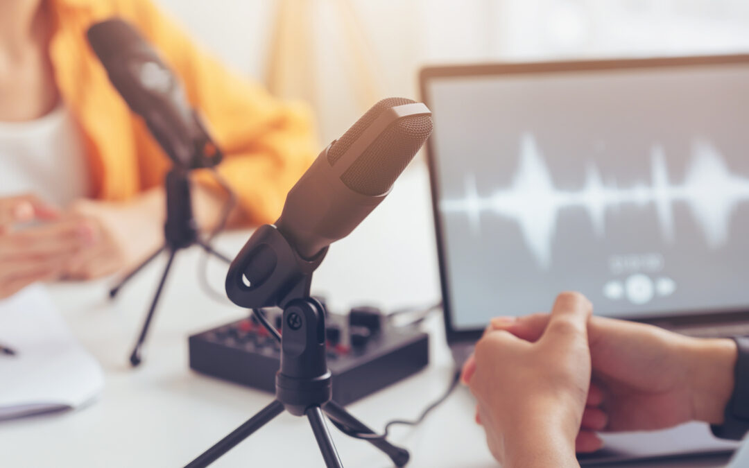 Young Asian woman use microphones wear headphones with laptop record podcast interview for radio.