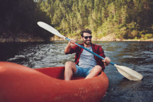 Young man kayaking on a lake.