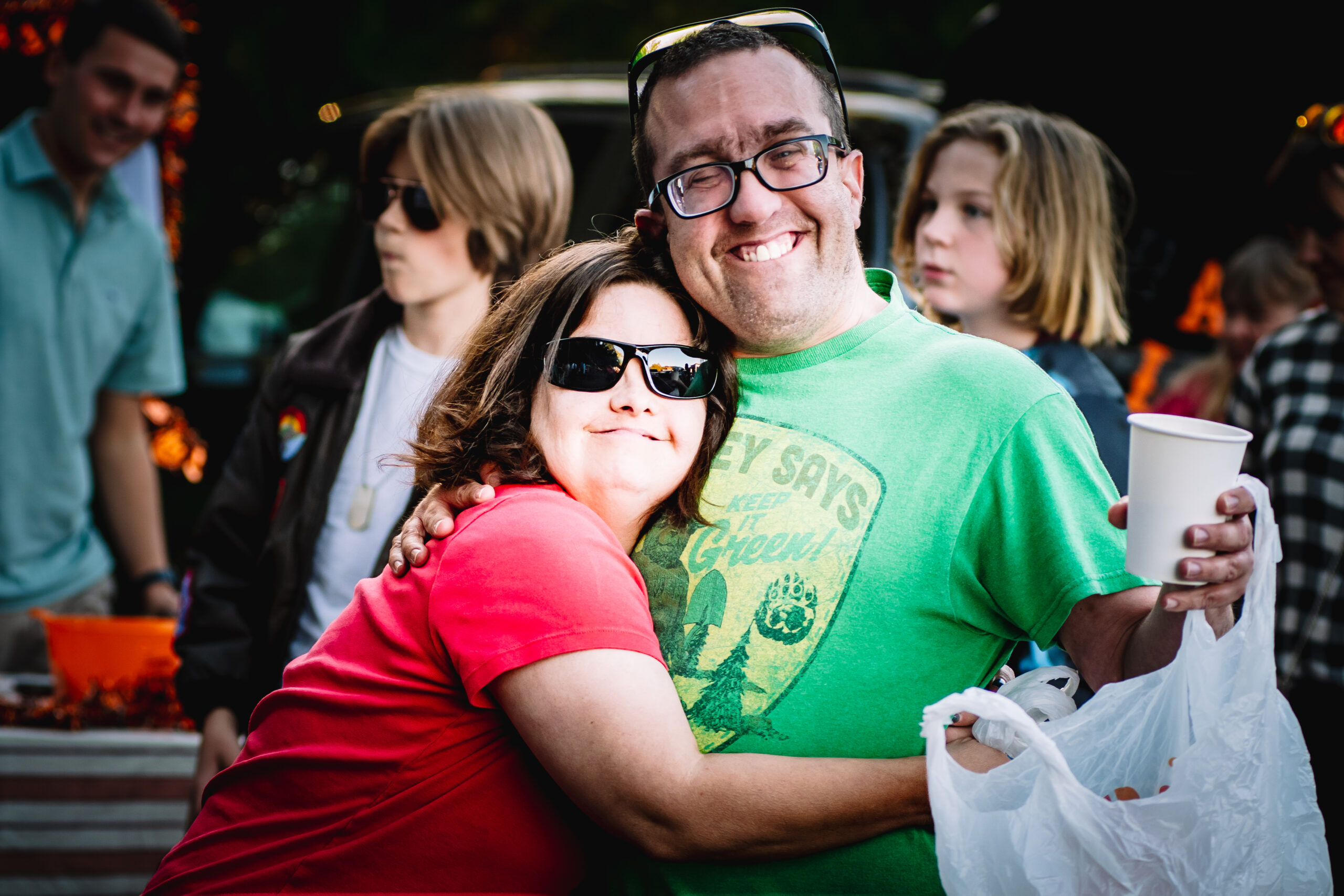 Two adults with developmental disabilities hug