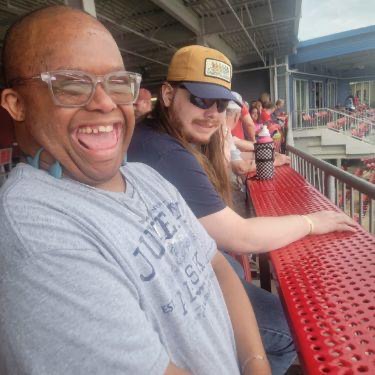 Two men smile in a baseball stadium