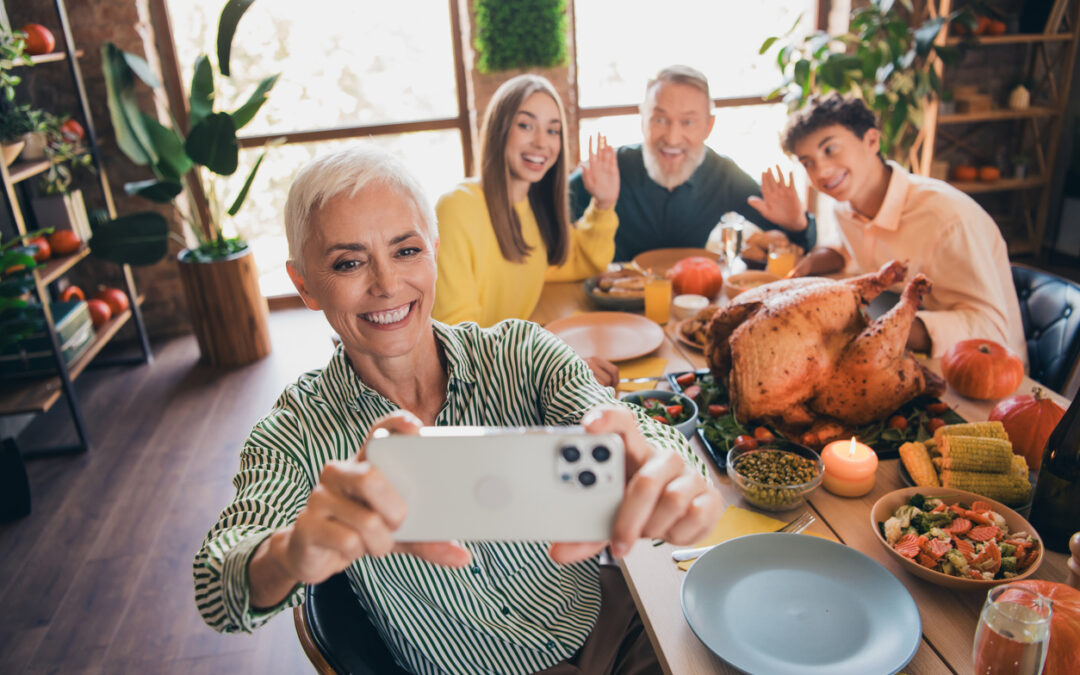 Portrait of big excited friendly family taking a selfie around a table with a turkey dinner