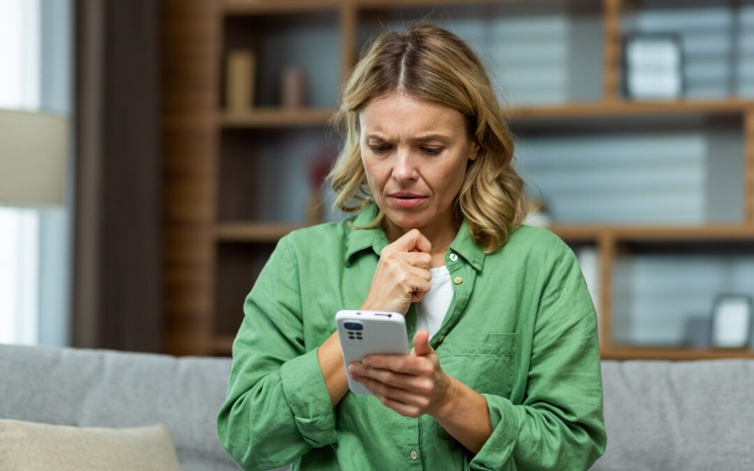 Woman in green shirt looks anxious while reading news on her smartphone