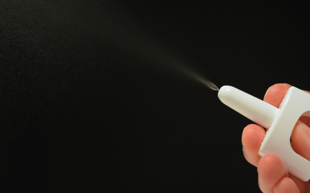 photo of hand holding the nasal spray version of naloxone