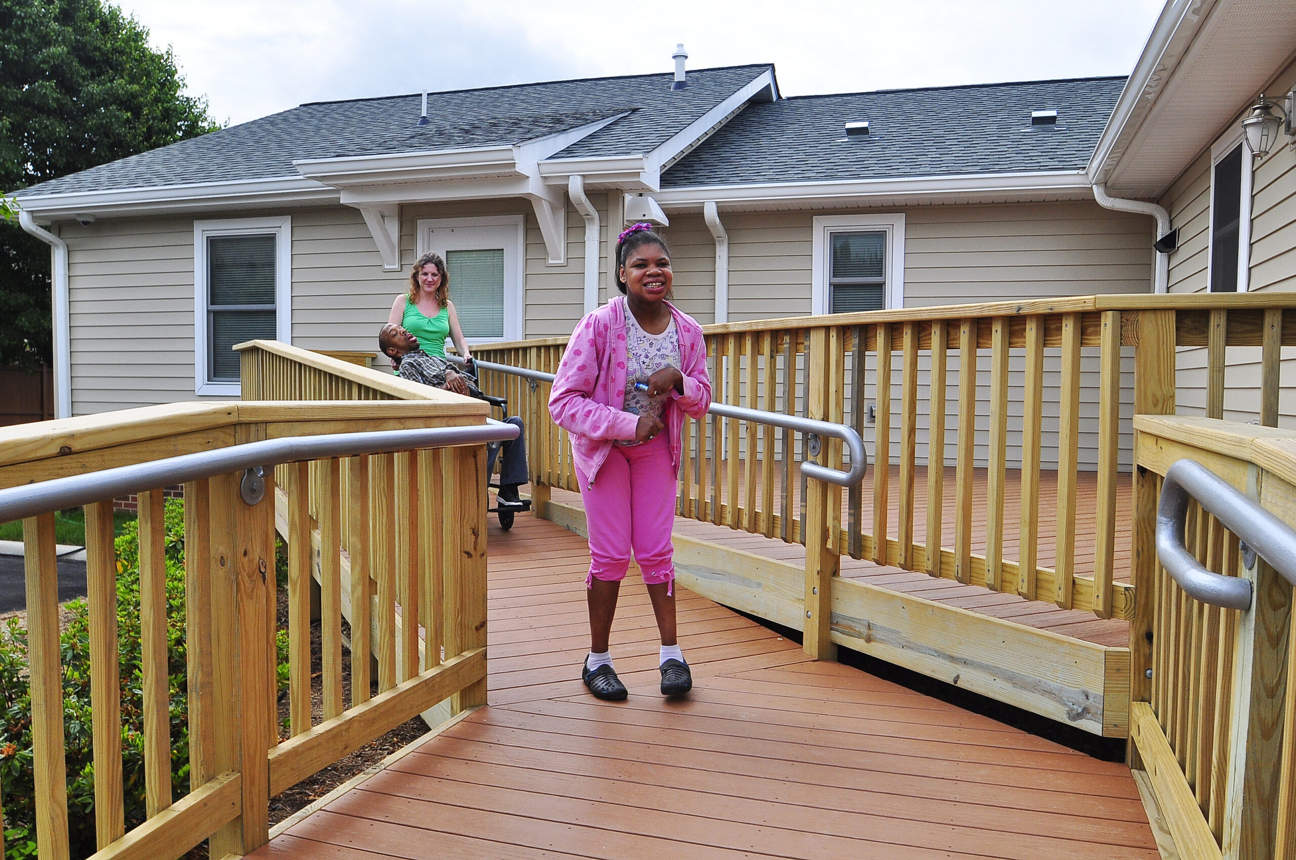 A young woman wearing pink walks down a ramp
